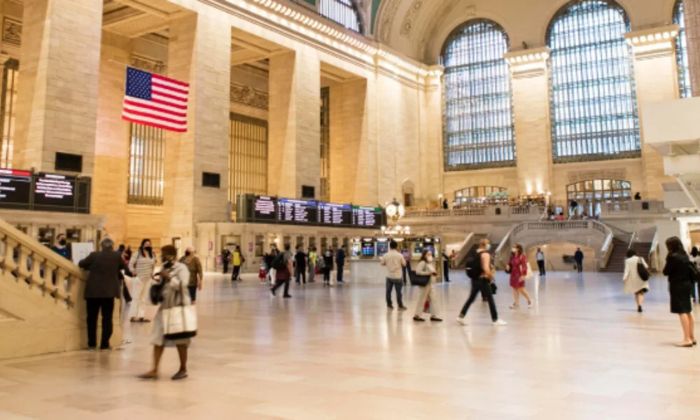 Grand Central Terminal's main concourse with a large American flag hanging-planning a trip to new york
