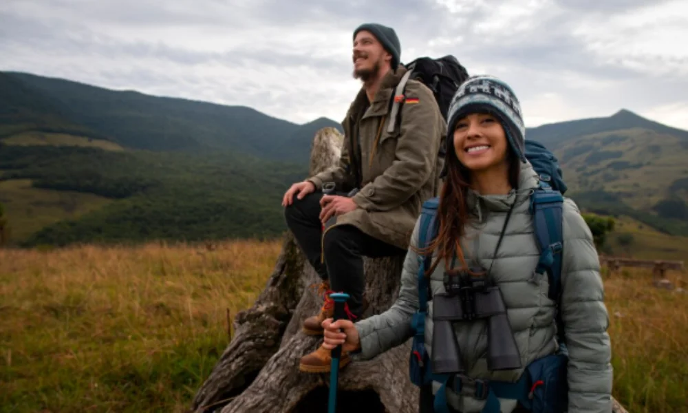 A couple of hikers resting on a log in the mountains-new zealand travel guide
