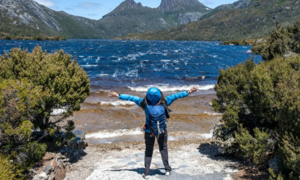 A woman stands on the steps leading to a lake