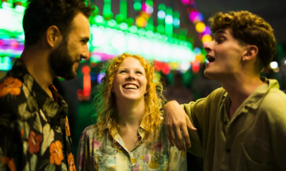 Three people are laughing and chatting in a vibrant setting with colorful lights in the background-Manhattan Travel Guide Map