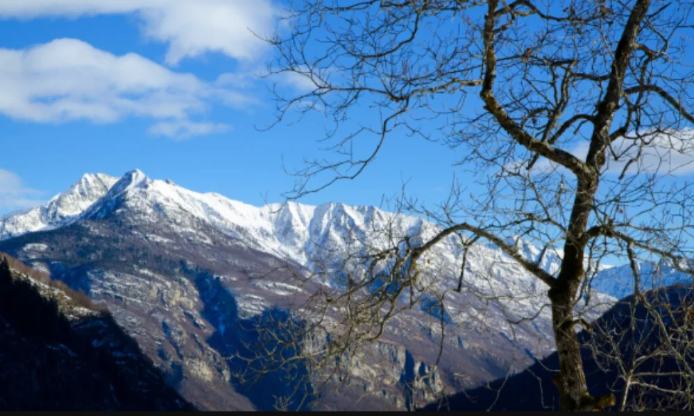 Snow-capped mountains under a bright blue sky with scattered clouds-good asian countries to visit