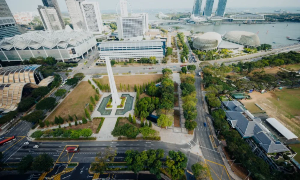 Aerial view of a cityscape with a tall white obelisk monument surrounded by greenery-countries in north asia