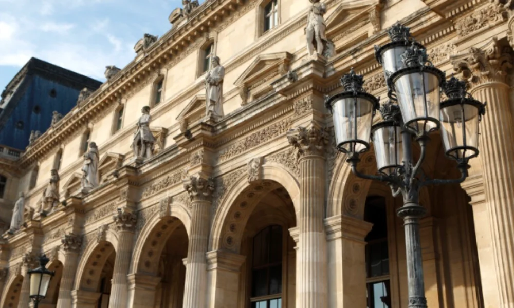Elegant facade of historic building with ornate arches and statues under a clear blue sky-mexico city travel guide