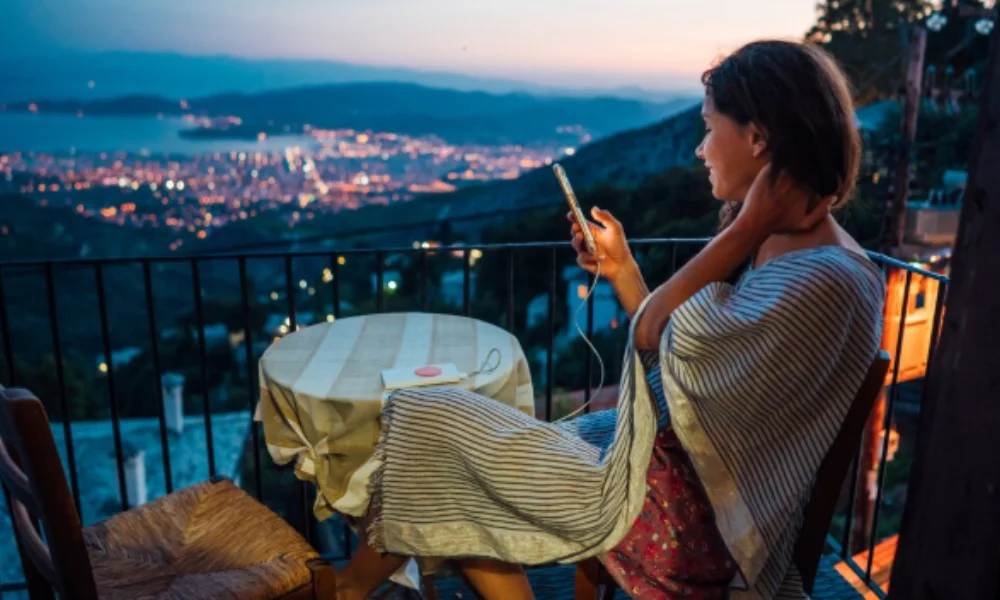 Woman wrapped in a blanket sits at a small table on a balcony-mexico city travel guide