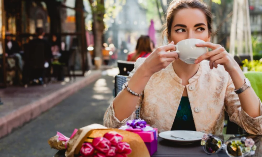 Woman sipping coffee at an outdoor cafe-rick steves paris hotels