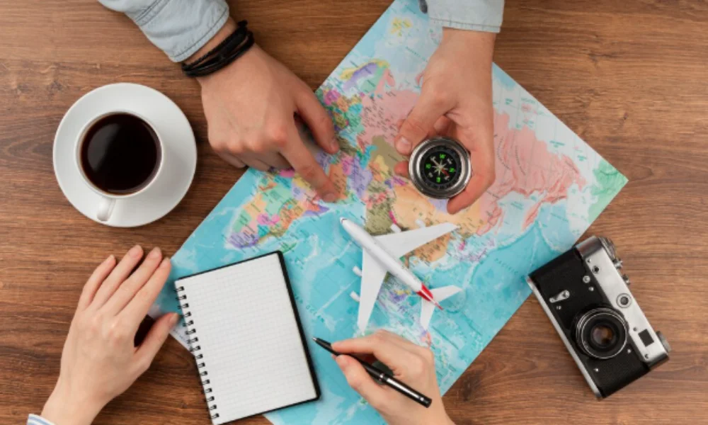 Hands point at a world map with a compass, toy plane