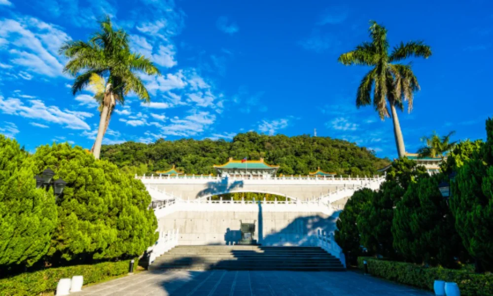 Grand white steps lead to a traditional building with green roofs
