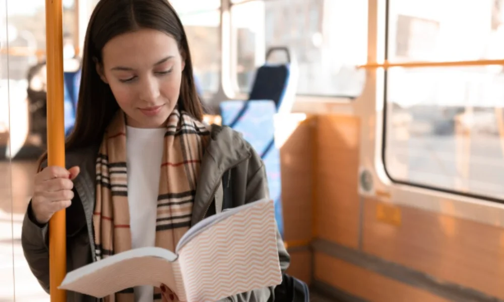 A woman reading a book while seated on a bus-rome travel guide map