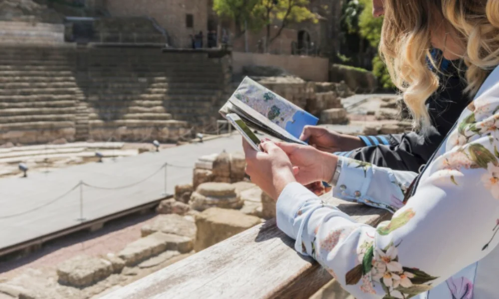 A woman studies a map while standing in front of an ancient theater-rome travel guide map