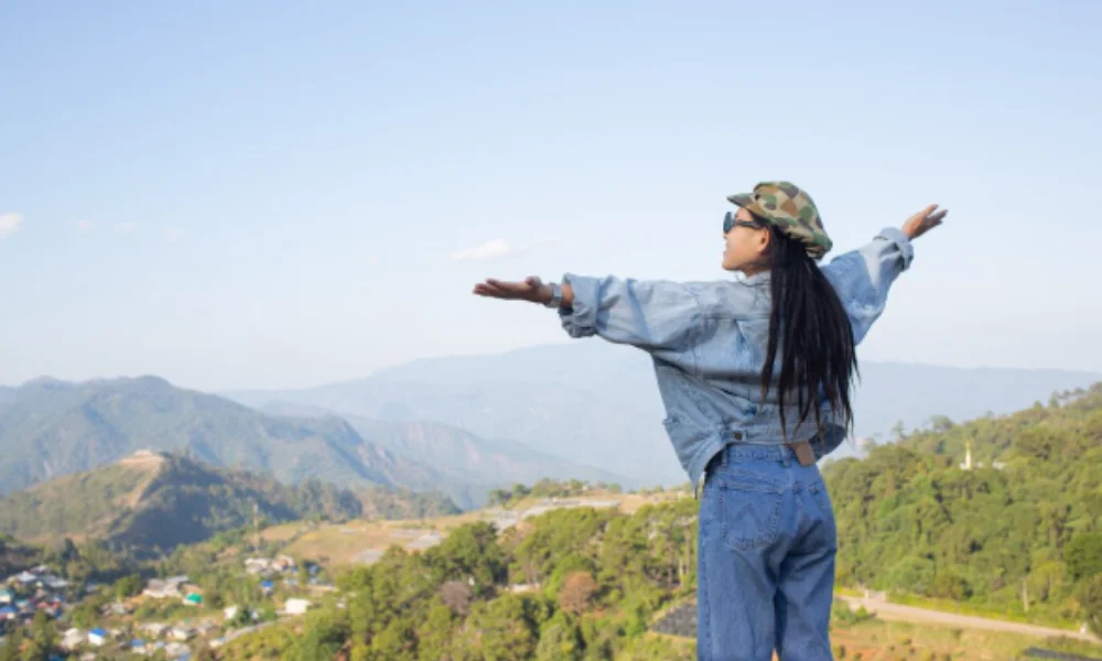 A person wearing a denim jacket and cap stands with arms outstretched-places to visit in guatemala