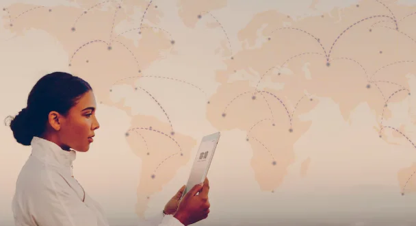 A woman in a white shirt looks at a tablet against a world map backdrop with connected nodes