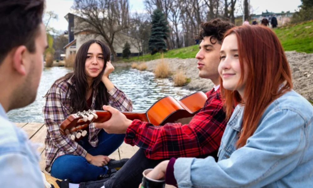 A group of four friends sits by a serene lakeside-things to do in washington state