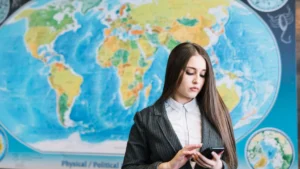 A young woman in a business suit looks focused as she uses her smartphone