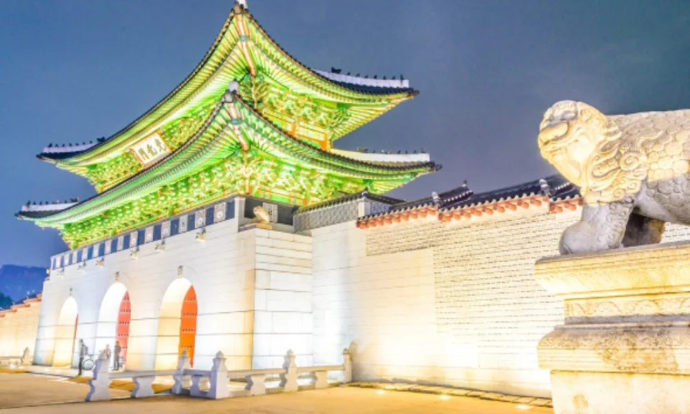 Illuminated traditional Korean gate with green-lit eaves at night