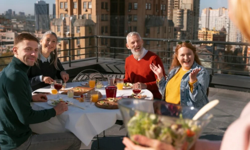 A group of four people enjoys an outdoor meal on a rooftop-washington dc travel guide