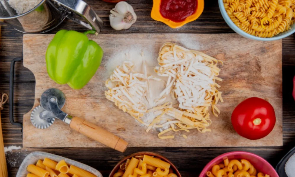 A rustic wooden cutting board with fresh pasta