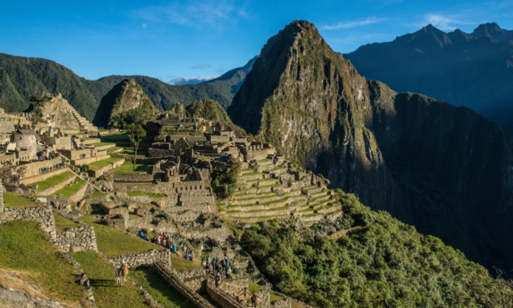 Machu Picchu at sunrise, with terraced stone ruins and lush green surroundings