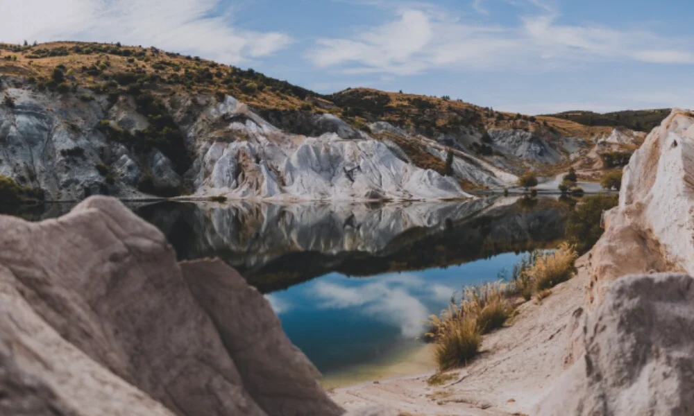 Rocky landscape with a serene lake reflecting the blue sky and clouds-places to visit in argentina