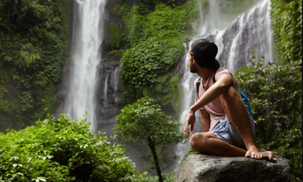 A man in casual attire and a cap sits on a rock-Places to Visit in Colombia