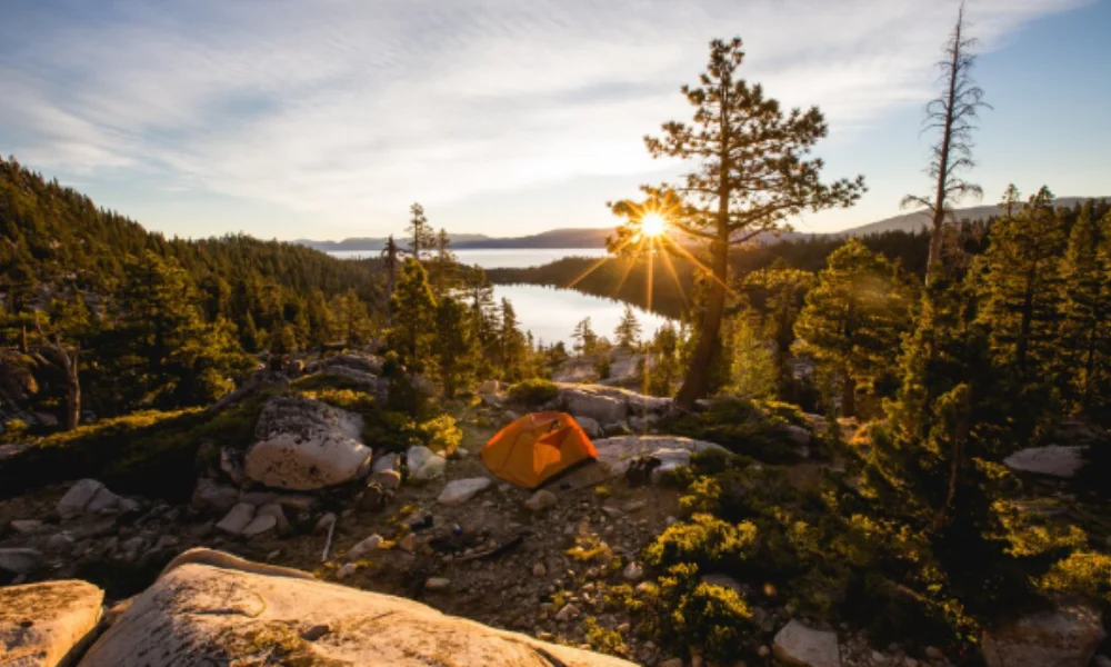 A bright sunrise over a serene forested lake