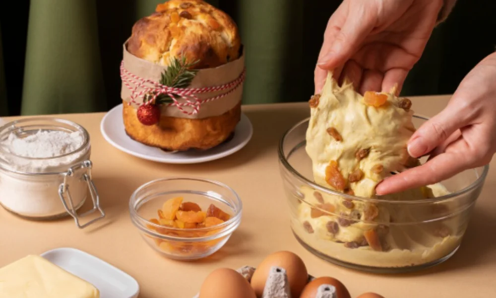Hands kneading dough with raisins and apricots in a glass bowl