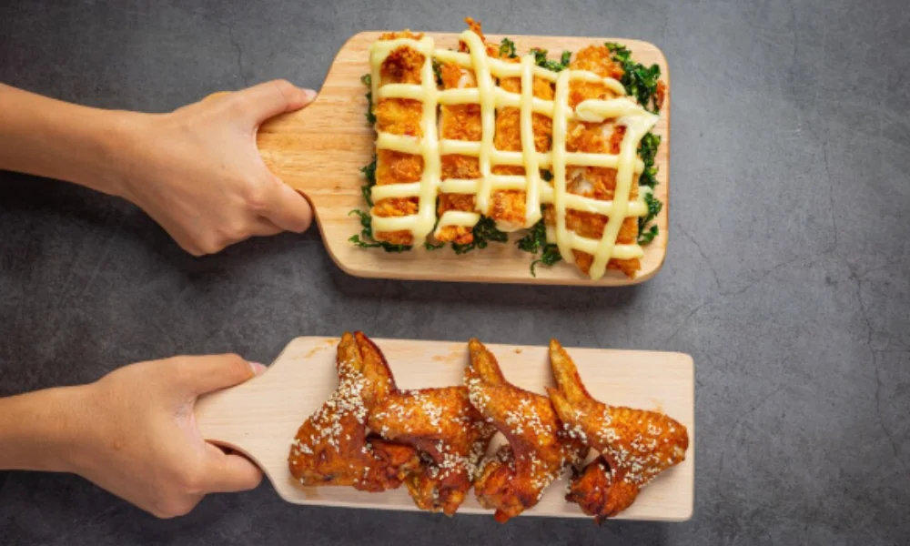 Two hands hold wooden boards with food