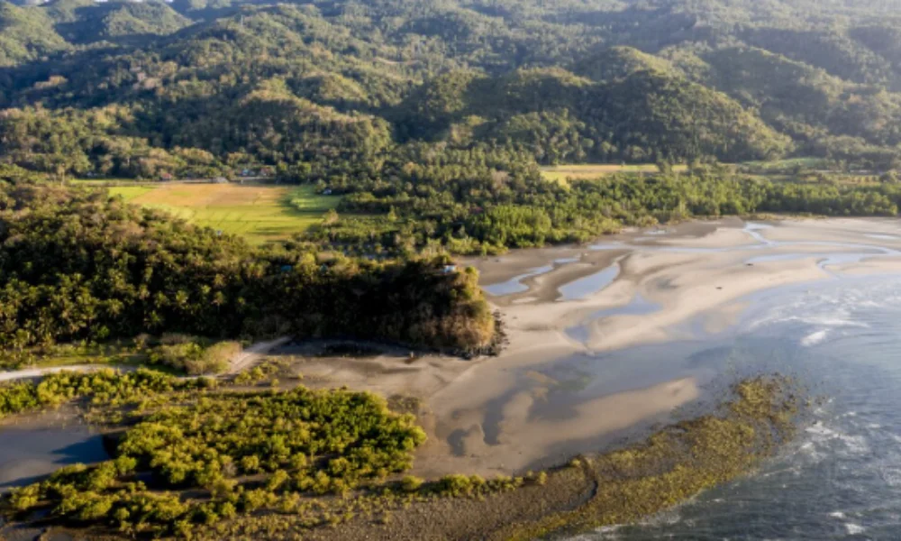 Aerial view of a serene coastal landscape with lush green hills-tropical places to visit