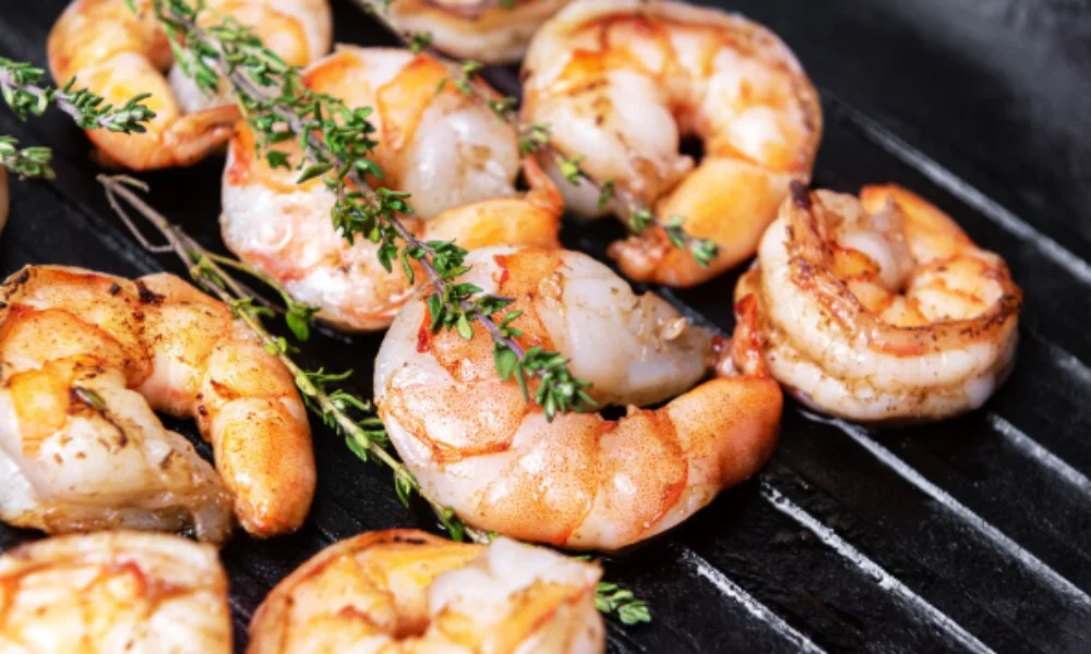 Grilled shrimp with a golden brown crust on a black grill-easy shrimp scampi recipe