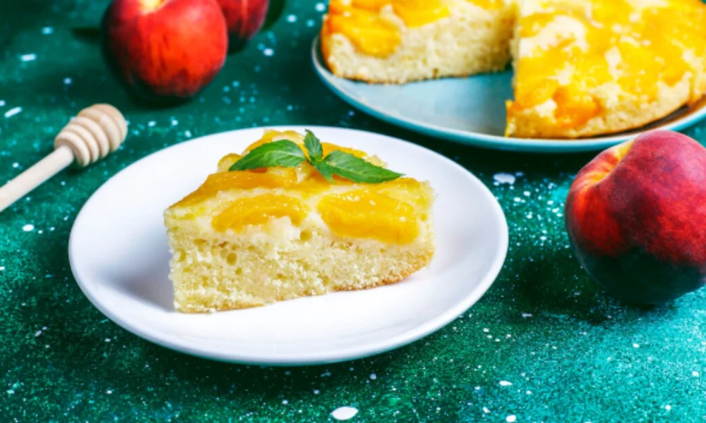 A slice of peach cake sits on a white plate-easy pineapple upside down cake recipe