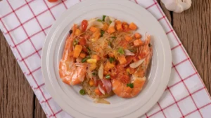 A plate of shrimp and glass noodle salad with diced vegetables
