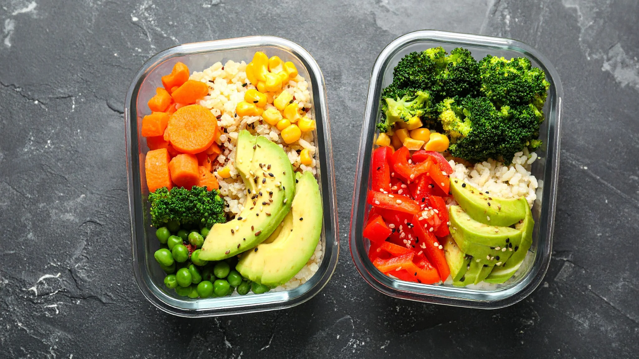 Two containers filled with colorful vegetables and rice, showcasing a healthy meal option.