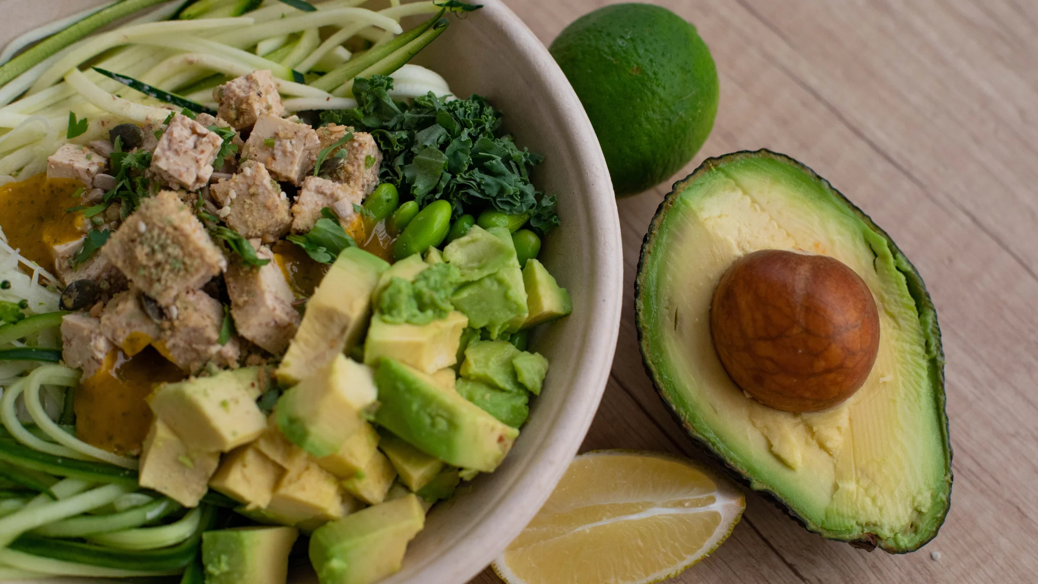 A colorful bowl filled with meat, fresh vegetables, and sliced avocado, ready to be enjoyed.