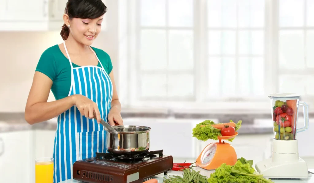 In a cozy kitchen, a woman wearing an apron is chopping vegetables and preparing a meal with care.