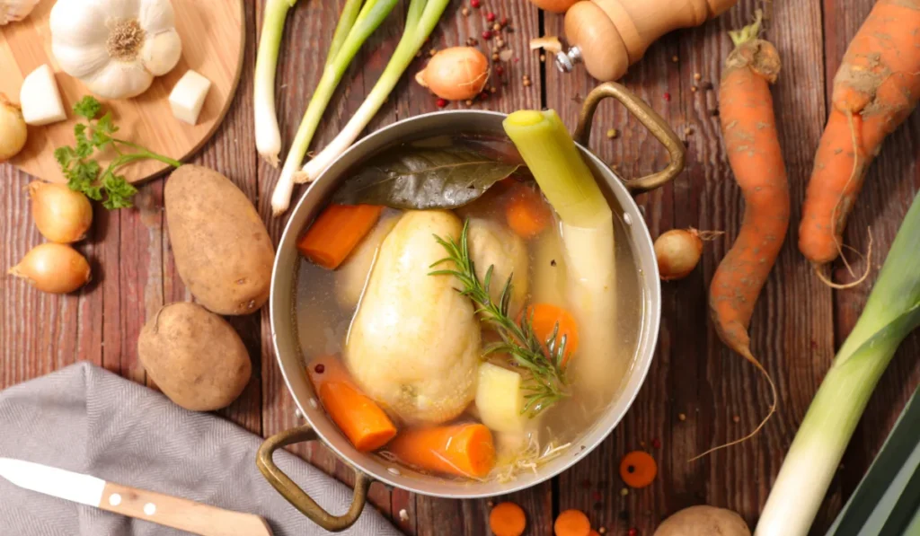 A bowl of colorful vegetable soup garnished with fresh herbs, steaming and inviting.