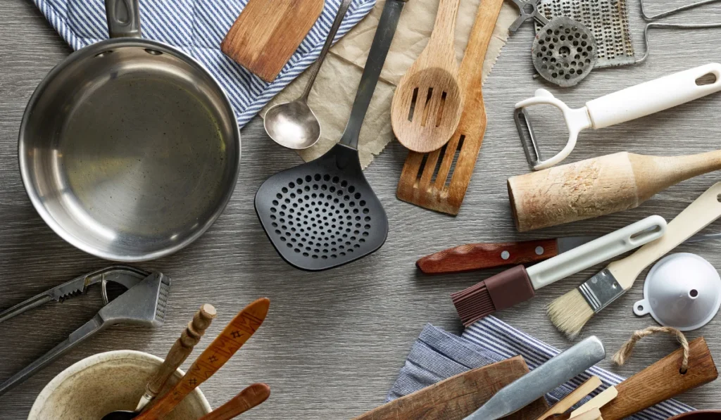A collection of kitchen utensils, including spatulas and whisks, displayed on a table, ready for culinary use.