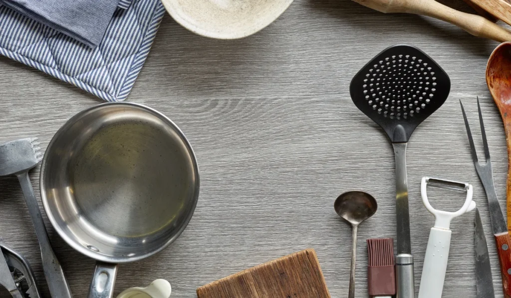 A collection of kitchen utensils, including spatulas and measuring cups, displayed on a table, ready for culinary use.