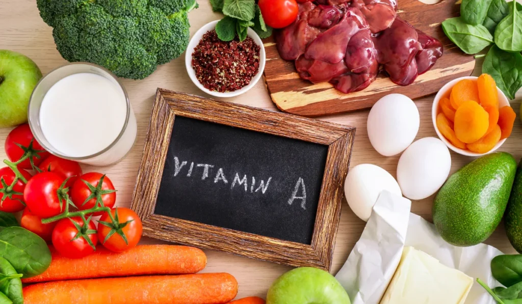 A vitamin A sign displayed with various foods such as carrots and kale, emphasizing their importance for health.