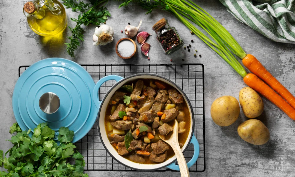 A hearty stew in a pot on a cooling rack-Healthy Crockpot Pot Roast