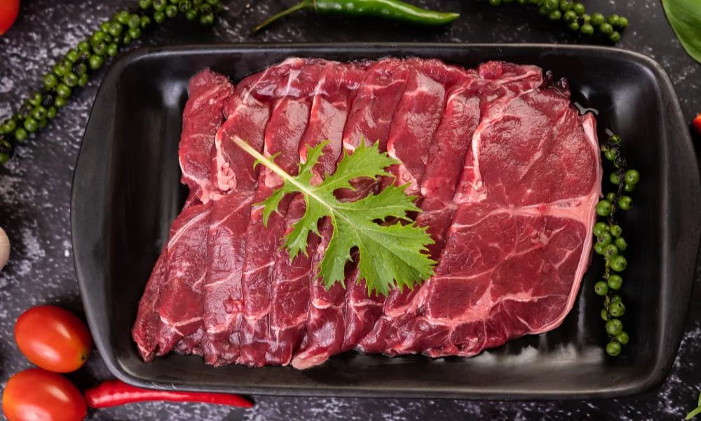 Fresh raw beef laid on a black tray