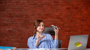 A woman in a striped shirt sits at a desk