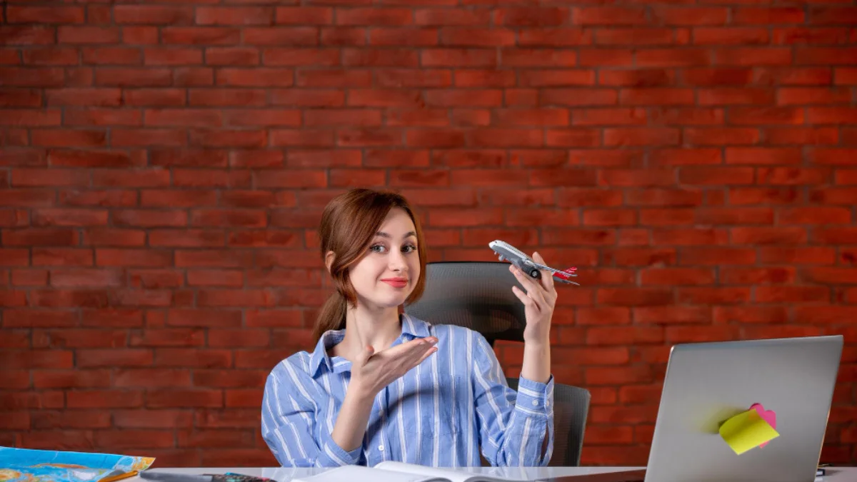 A woman in a striped shirt sits at a desk
