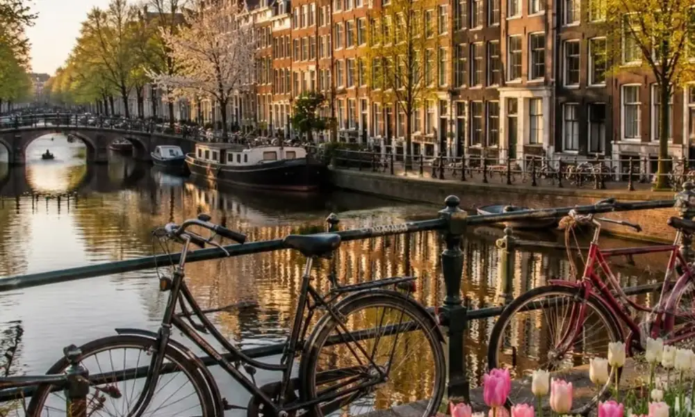 Amsterdam canal with bicycles, historic townhouses, and spring tulips for Best Places to Visit in Spring.