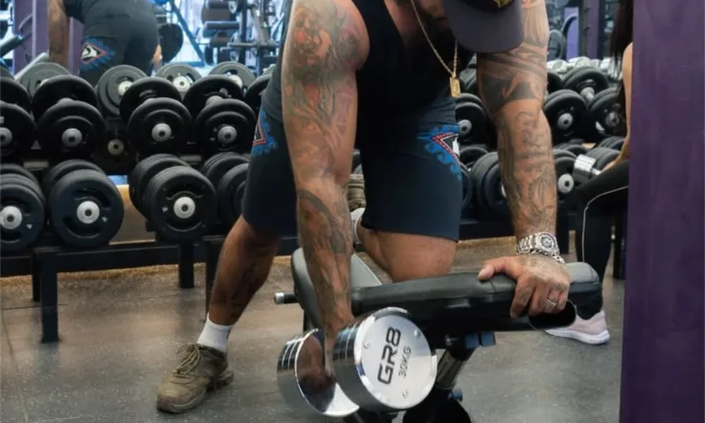 Single-arm heavy dumbbell row exercise on a workout bench for Best Workout Routines for Beginners.