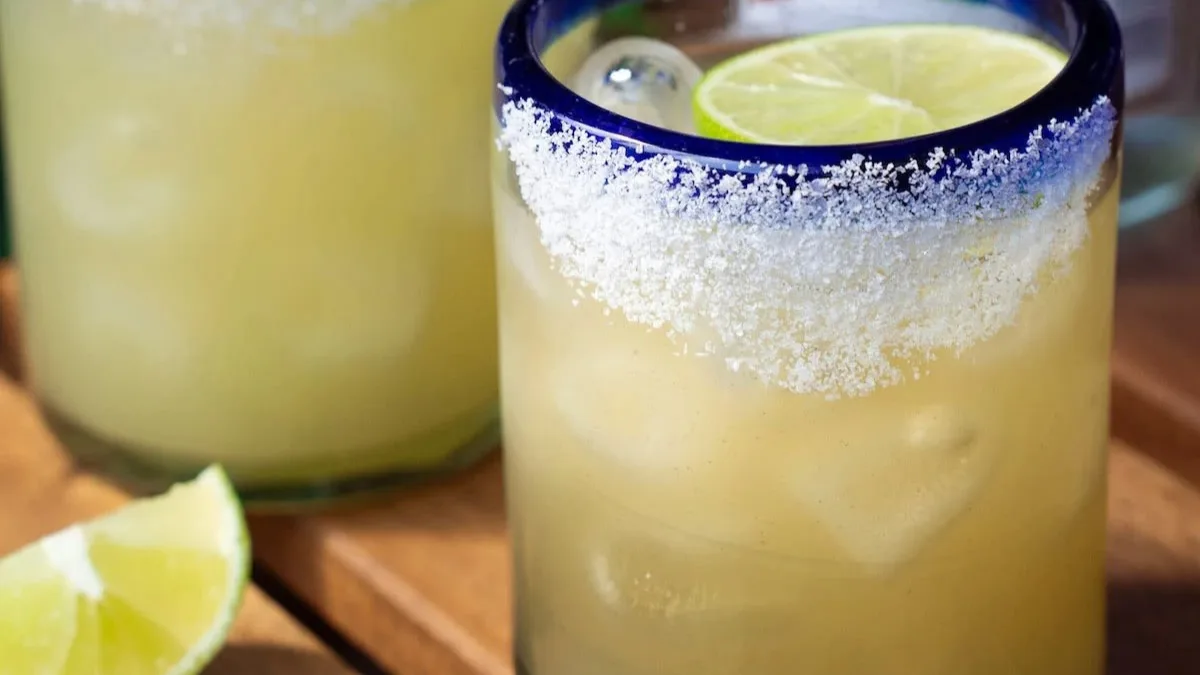 Freshly made cocktail with a salted rim and lime slice, highlighted in perfect margarita recipes.