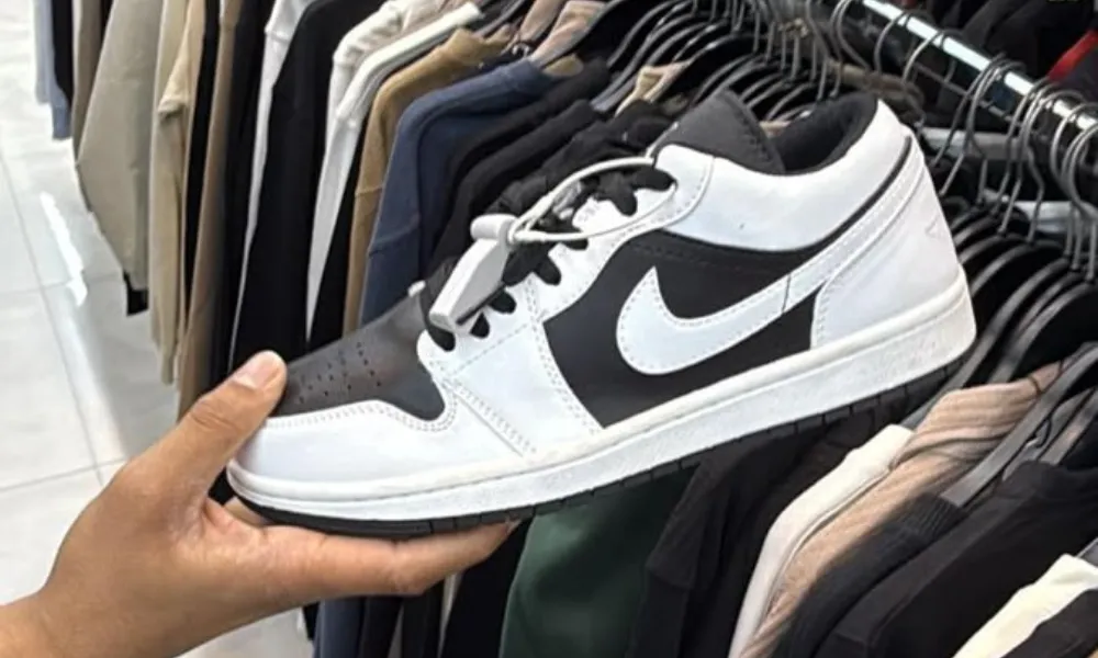 Black and white sneakers on display beside clothing racks for Best camping gear checklist 2026.