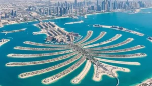 5 must visit places in Dubai title card featuring an aerial view of Palm Jumeirah and the Dubai skyline to make your travel trip unforgettable.