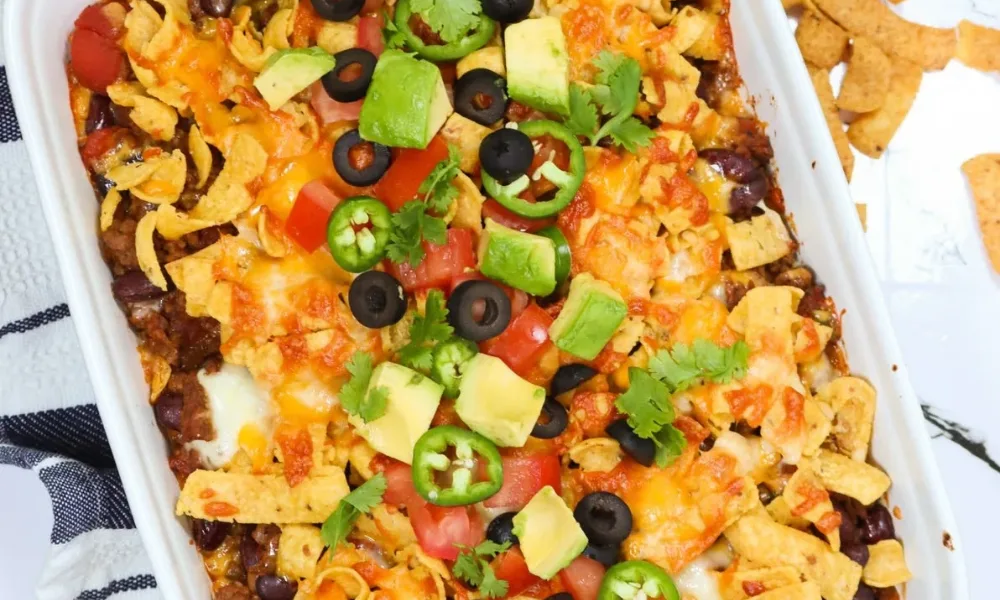 Baked frito pie casserole loaded with cheese, avocado, and chili.