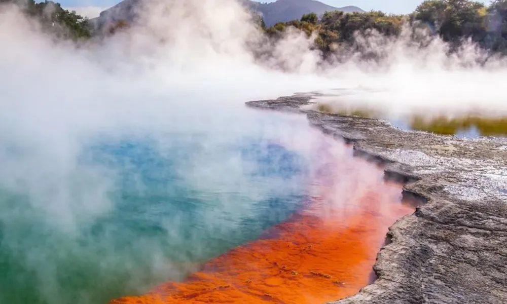 Geothermal pool landscape with steam rising in Rotorua for Best Places to Visit in New Zealand.