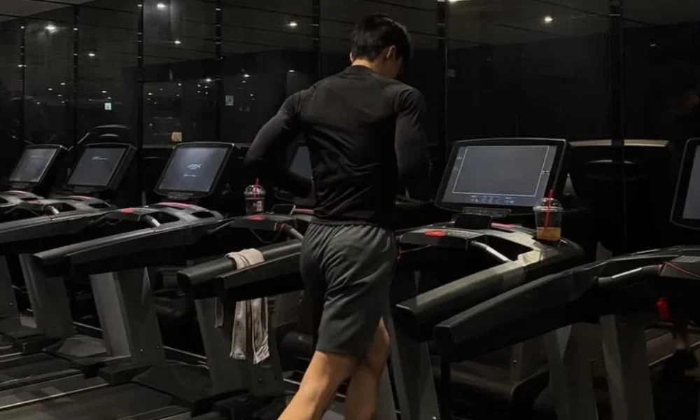Man performing cardio on a treadmill in a fitness gym for Best Workout Routines for Beginners.